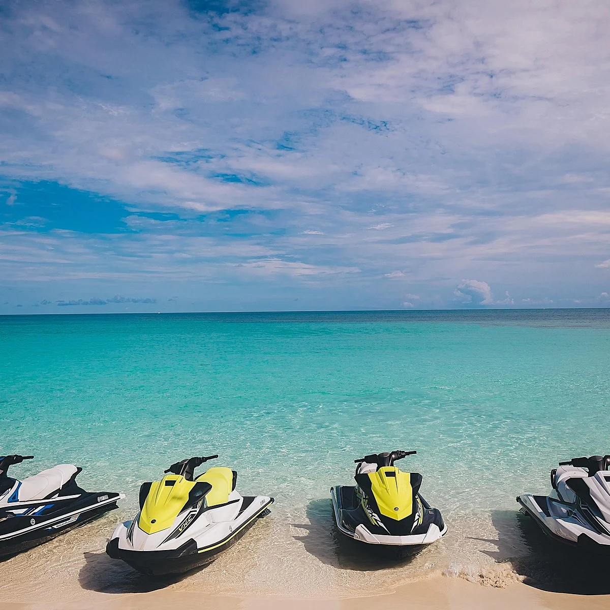 Jet Skis lined up on a clear Nassau beach